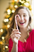 Young woman holding candy cane