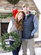 Mid adult couple holding wreath