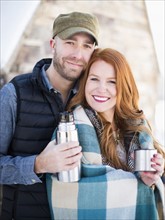 Portrait of mid adult couple having drink from vacuum flask, looking at camera