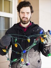 Front view portrait of young man with Christmas light