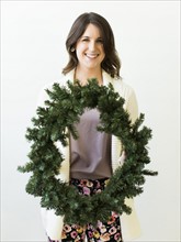 Studio shot of woman holding Christmas wreath