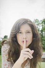 Portrait of woman with finger on lips