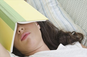 Woman sleeping with book on face