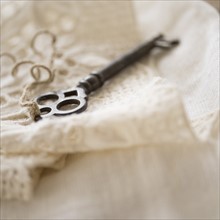 Studio shot of antique key on lace cloth.