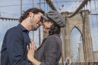 Happy couple kissing on Brooklyn Bridge. Brooklyn, New York.