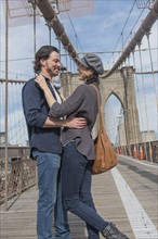 Happy couple embracing on Brooklyn Bridge. Brooklyn, New York.