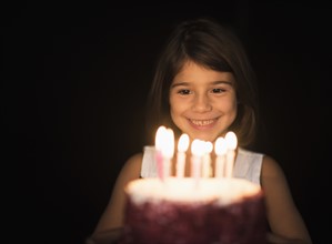 Portrait of girl (6-7) with birthday cake.