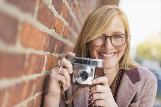 Woman holding vintage camera. .