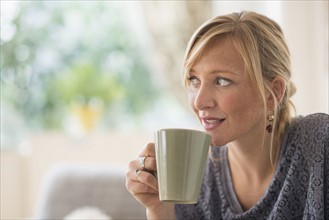 Pensive woman drinking coffee.