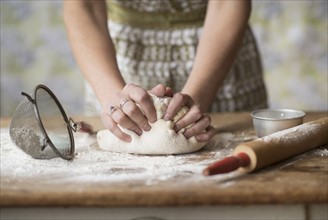 Woman kneading dough.