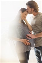 Man kissing pregnant woman.