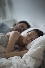Couple sleeping together in bed at night.