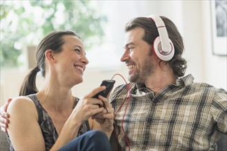 Cheerful couple listening to music at home.