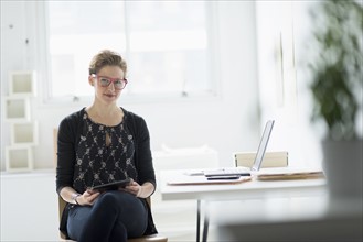 Portrait of businesswoman using digital tablet in office.