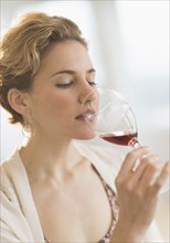 Young woman drinking red wine.