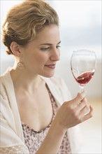 Young woman swirling glass of red wine.