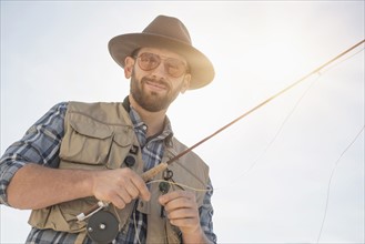 Portrait of man holding fishing rod.