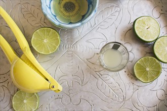 Limes and shot glass on table