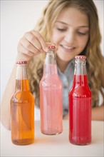 Girl (12-13) and three soda bottles