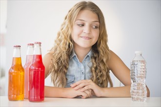 Girl (12-13) choosing between water and soda