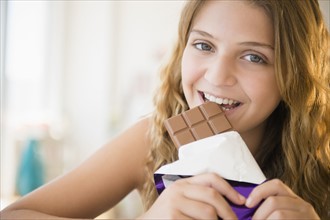 Girl (12-13) eating chocolate