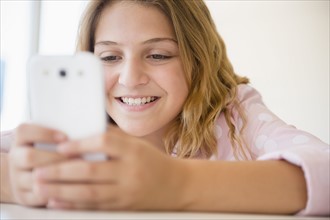 Girl (12-13) using smartphone