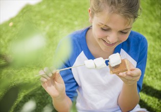 Girl (12-13) eating marshmallows