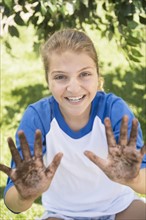 Girl (12-13) with dirty hands