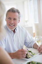 Portrait of man eating and drinking white wine at restaurant