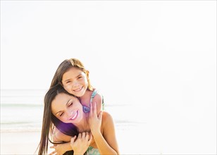 Portrait of smiling girl (6-7) with her mom on beach