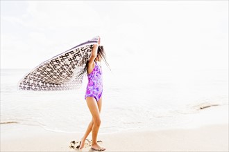 Girl (6-7) spinning on beach