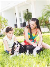 Girl (6-7) with mom and dog in backyard