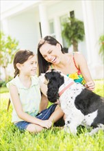 Girl (6-7) with mom and dog in backyard