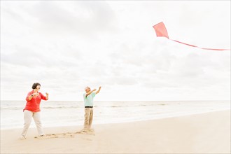 Couple flying kite together on beach