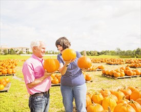 Couple talking and holding pumpkins