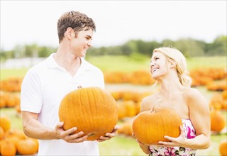 Portrait of young couple holding pumpkins