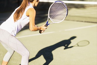High-section shot of young woman playing tennis in outdoor court