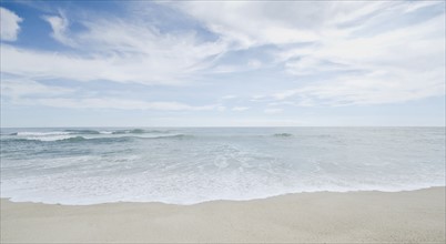 Seascape with surf on sandy beach