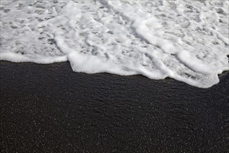Close-up view of sandy beach and wave