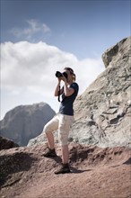 Woman photographing in mountains