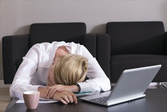 Business woman sleeping on desk near computer