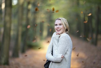 Portrait of smiling woman while leaves falling