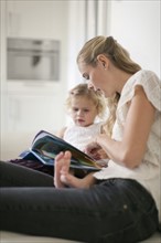 Woman teaching young girl (2-3) at home