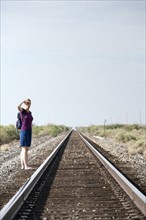 Woman standing by railroad track