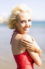 Portrait of woman wearing red swimming costume on beach