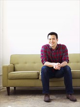Man in checked shirt sitting on sofa