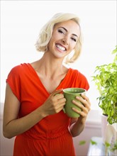 Woman in red dress holding green mug