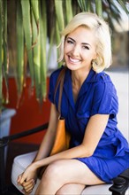 Woman with dyed hair sitting and smiling to camera