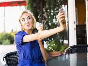 Woman photographing herself with ice-cream