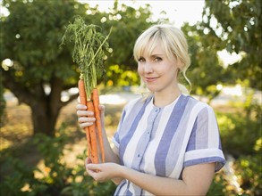 Woman wearing striped dress working in vegetable garden